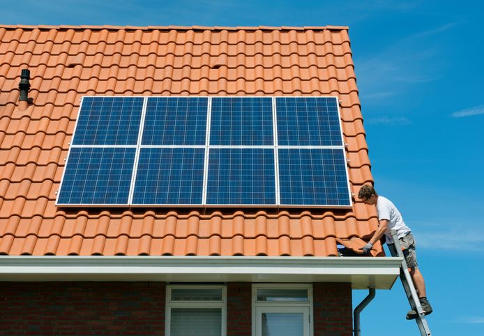 Installateur legt laatste dakpan terug op dak na installatie zonnepanelen